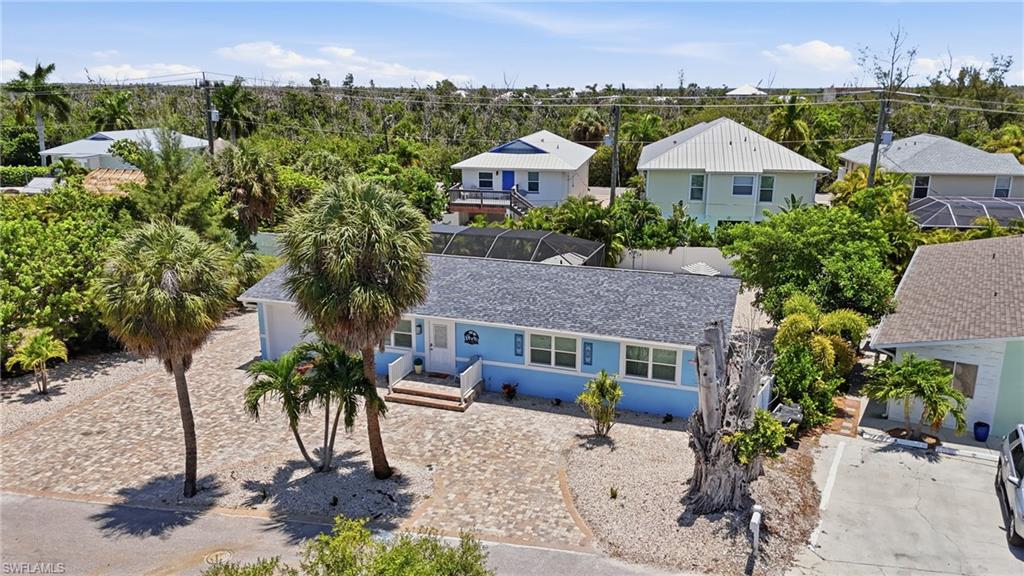 Light blue exterior with white trim, featuring a dark shingle roof and a front porch with white railings - Virtually Edited Image