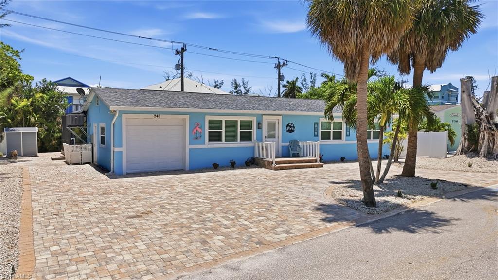 Light blue single-story residence featuring a white garage door and multiple windows - Virtually Edited Image