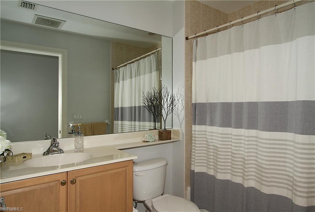 Bathroom featuring vanity and shower / bath combination with curtain