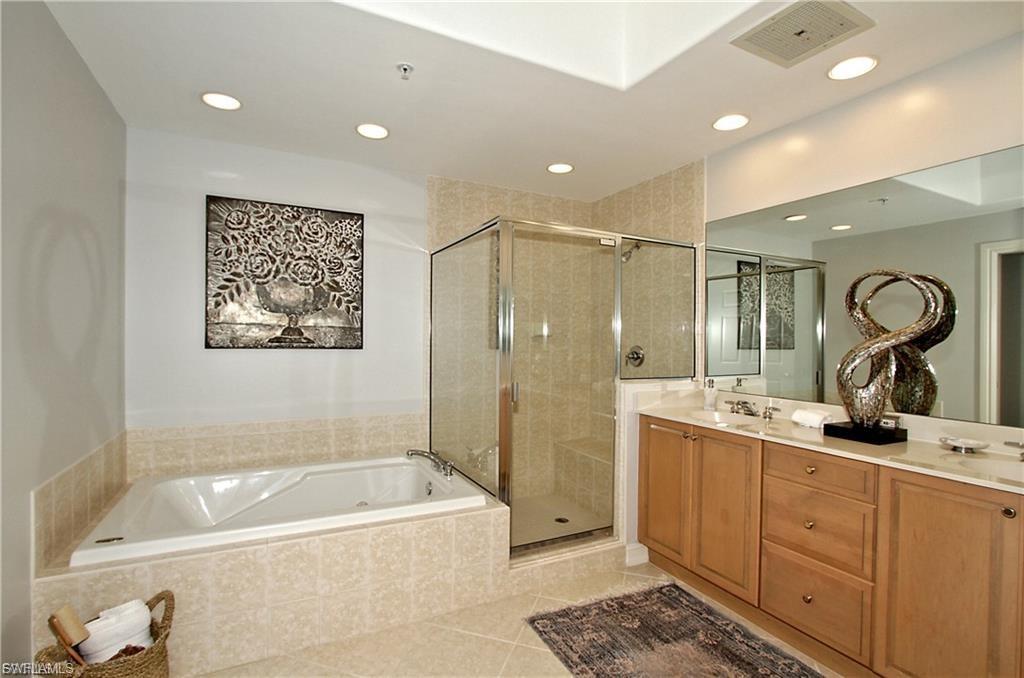 Bathroom with double vanity, a garden tub, a shower stall, light tile patterned floors, and recessed lighting