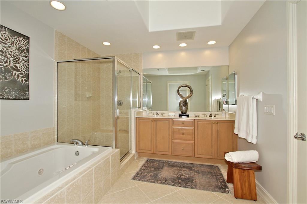 Full bathroom featuring double vanity, a jetted tub, light tile patterned flooring, a shower stall, and recessed lighting