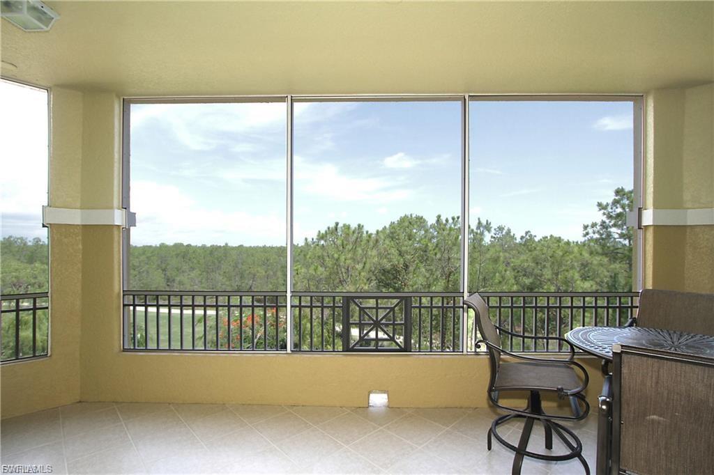 Sunroom / solarium with a wooded view