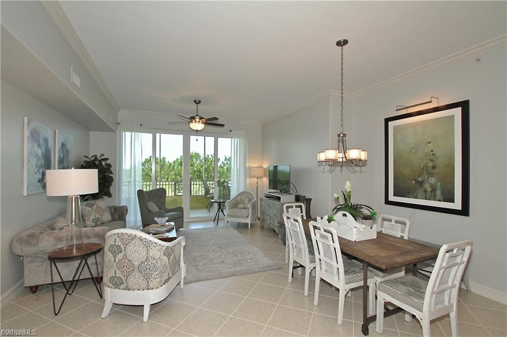 Dining space featuring ceiling fan, crown molding, hanging lights, and light tile patterned floors