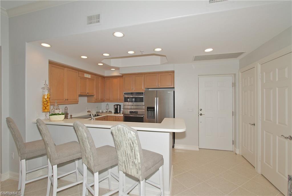 Kitchen featuring recessed lighting, light countertops, a kitchen breakfast bar, stainless steel appliances, and a peninsula
