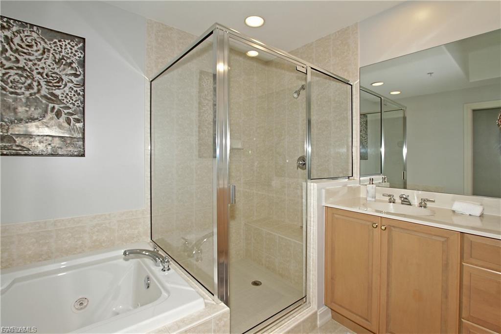 Full bath with vanity, a stall shower, a tub with jets, and recessed lighting