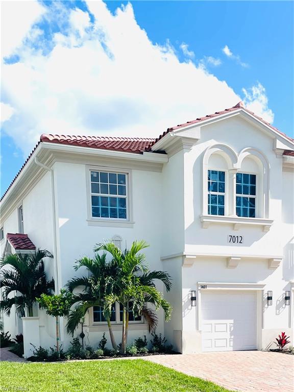 Mediterranean / spanish-style house featuring a tile roof, stucco siding, and an attached garage