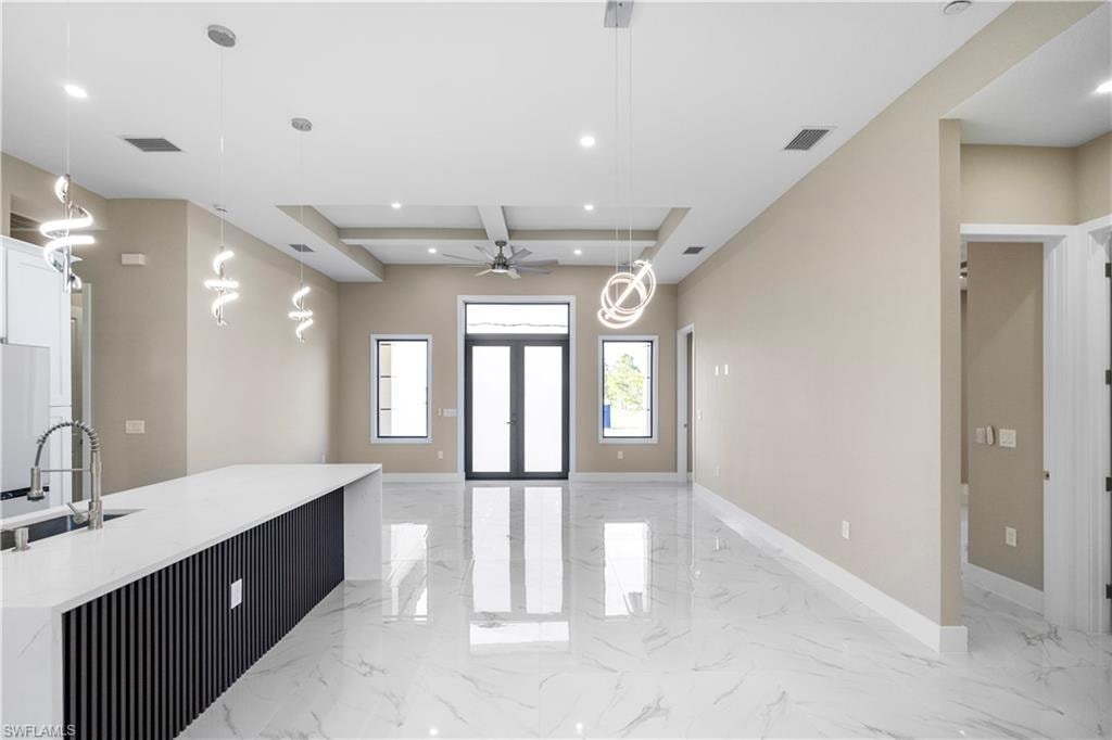 Entrance foyer with light marble finish flooring, recessed lighting, coffered ceiling, and a ceiling fan