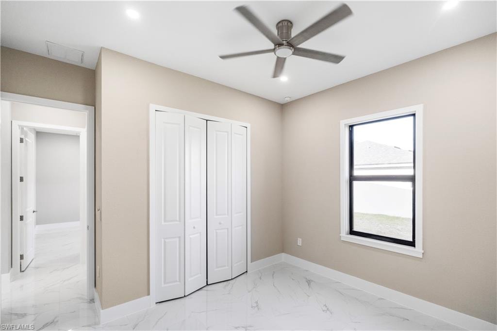 Unfurnished bedroom with light marble finish flooring, ceiling fan, a closet, and recessed lighting
