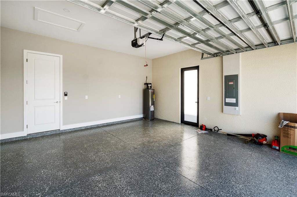 Garage featuring water heater and electric panel