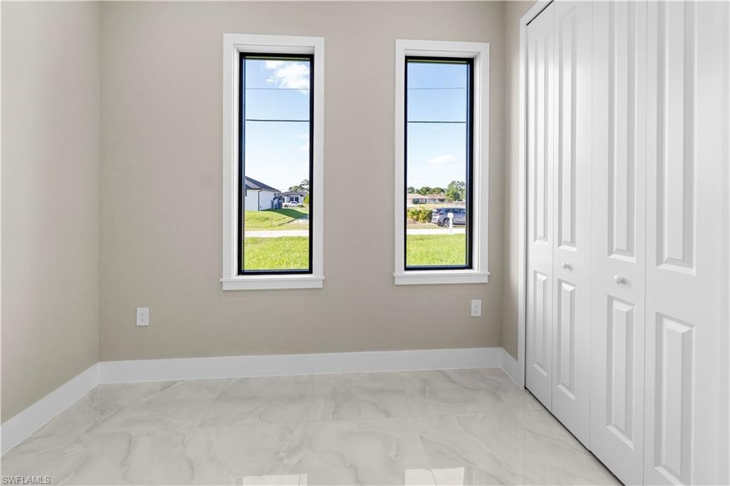 Unfurnished bedroom with a closet and baseboards