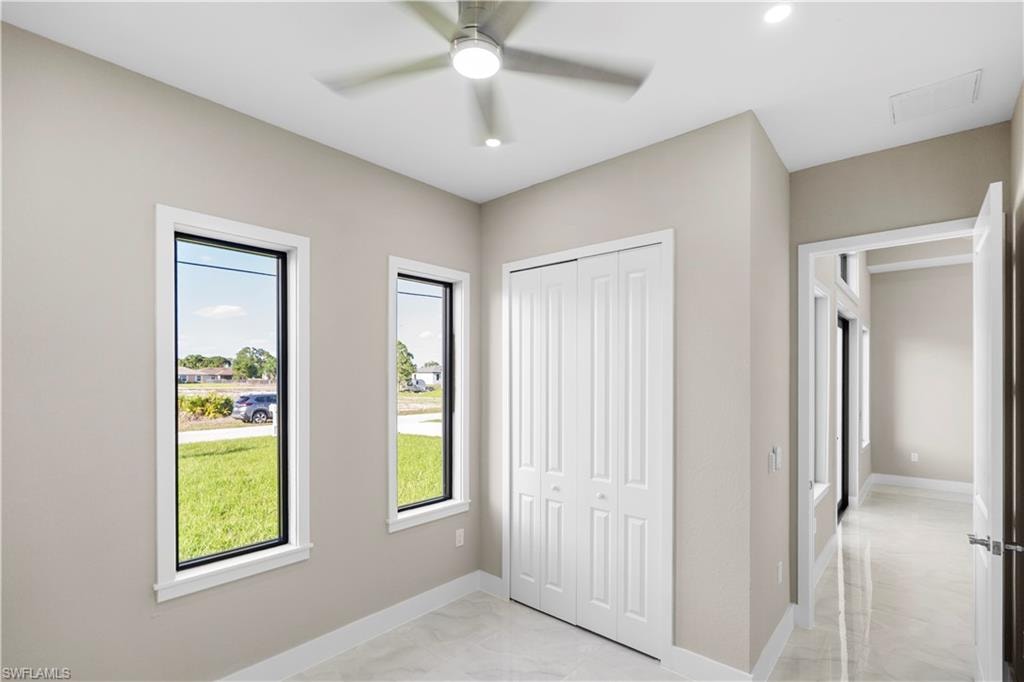 Unfurnished bedroom with a closet, light marble finish flooring, a ceiling fan, and recessed lighting