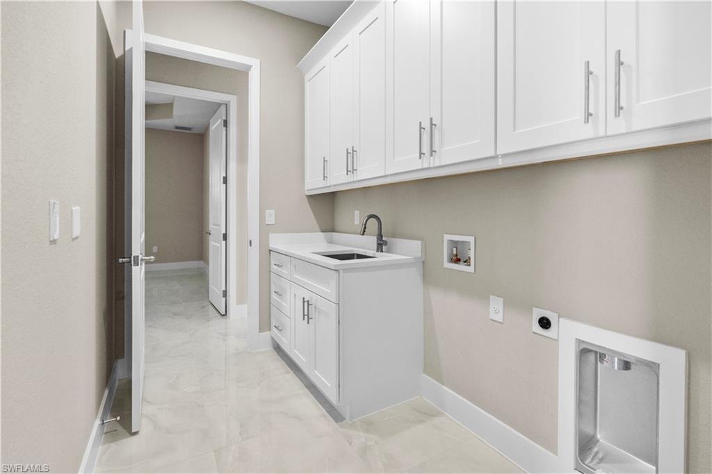 Laundry room with cabinet space, washer hookup, hookup for an electric dryer, and light marble finish floors