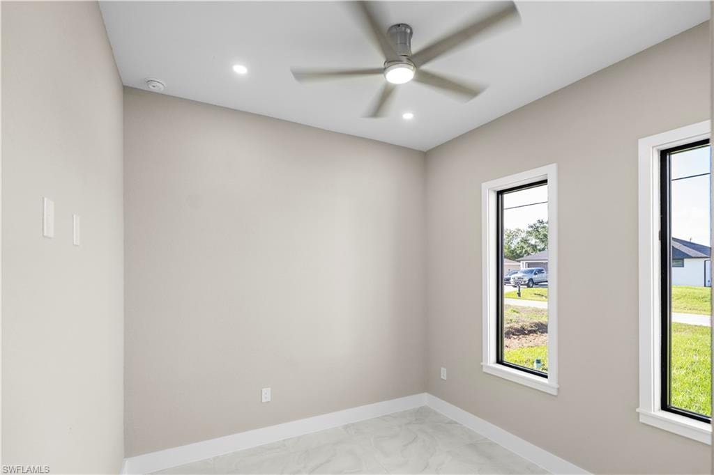 Empty room featuring light marble finish floors, recessed lighting, and a ceiling fan