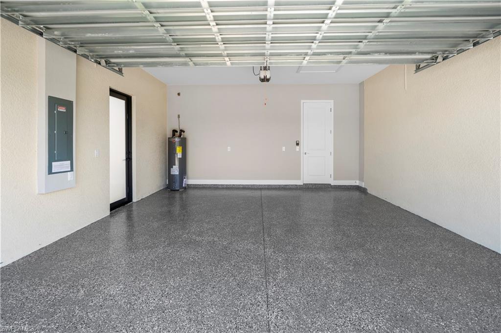 Garage featuring electric panel and electric water heater