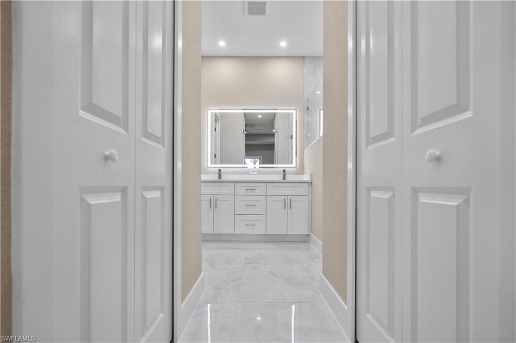 Master Full bathroom featuring a closet, double vanity, light marble finish flooring, and recessed lighting