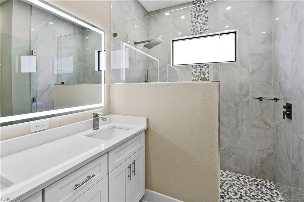 Master Bathroom featuring a marble finish shower and vanity