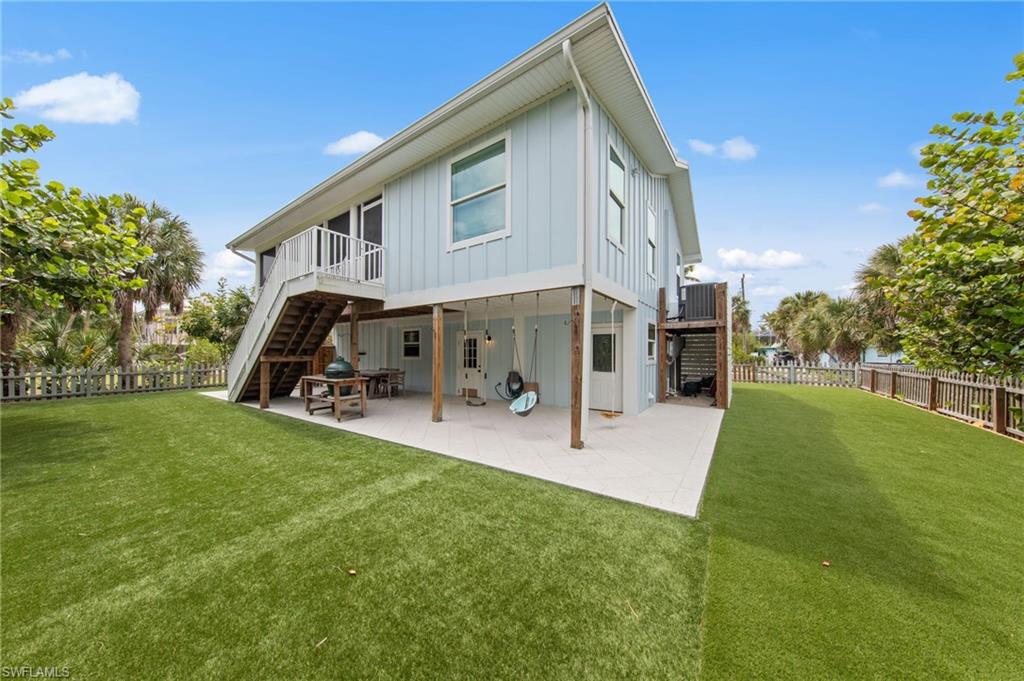 Back of house with a patio, board and batten siding, a fenced backyard, and a deck