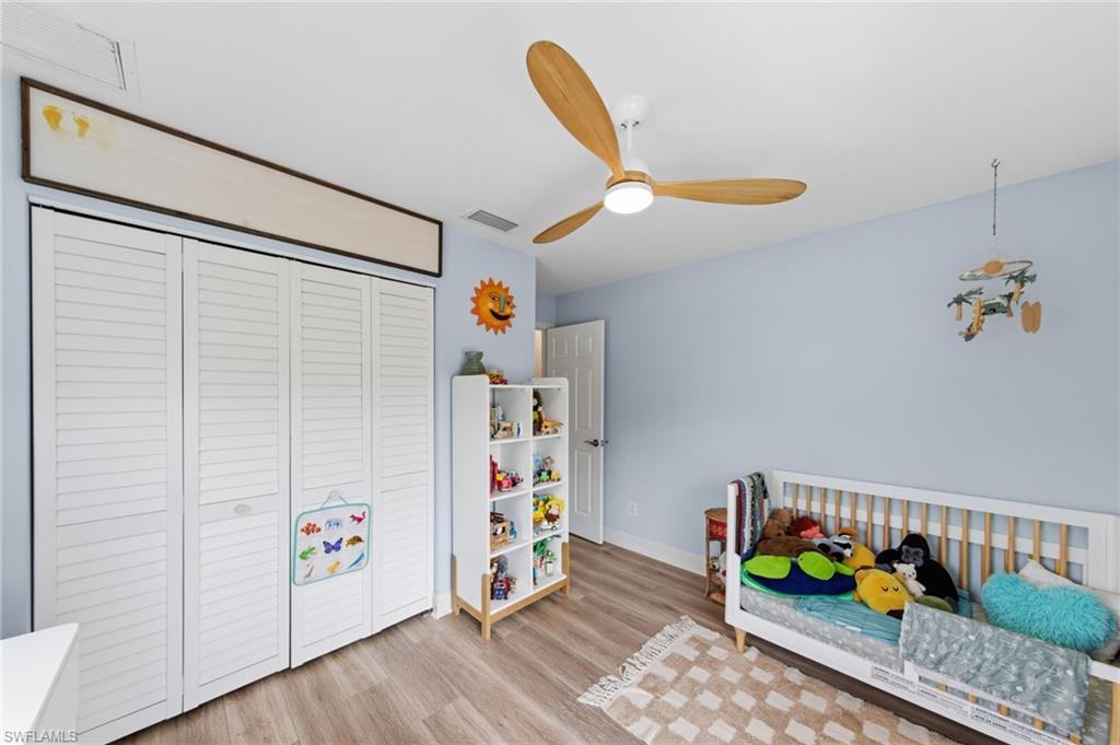 Bedroom featuring light wood finished floors, a closet, and ceiling fan