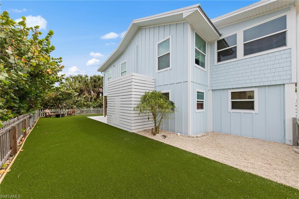 Rear view of house featuring board and batten siding and a fenced backyard