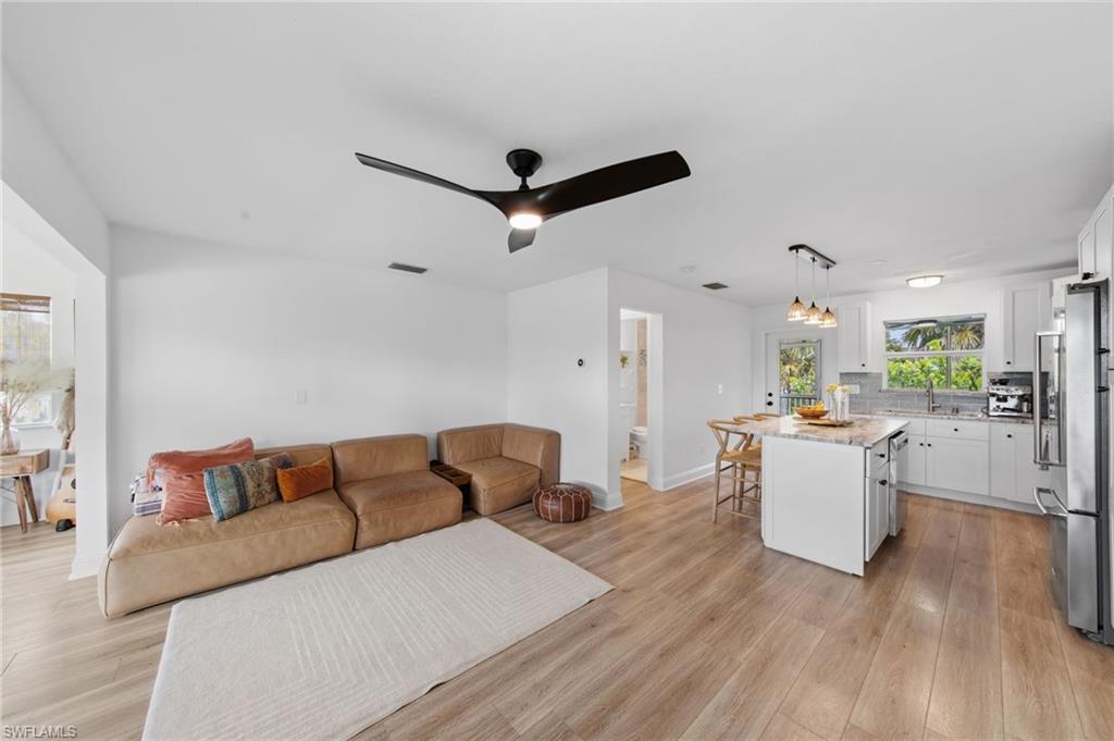 Living room with light wood finished floors and ceiling fan