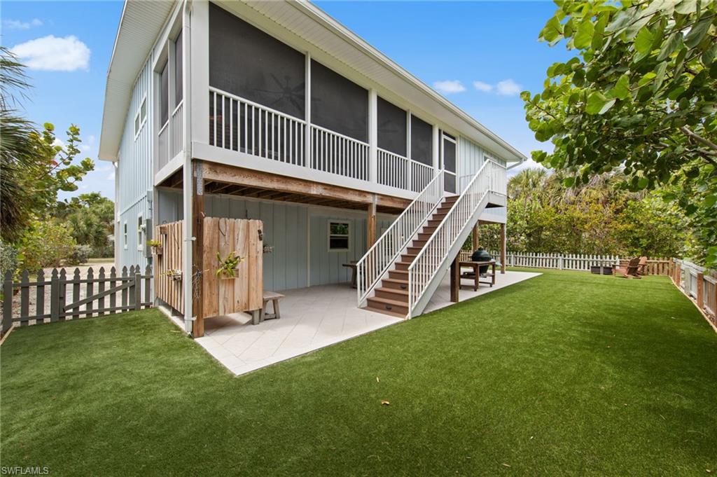 Rear view of property with a patio area, a sunroom, a fenced backyard, and board and batten siding