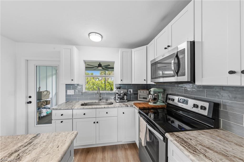 Kitchen featuring stainless steel appliances, white cabinetry, and light wood-style flooring