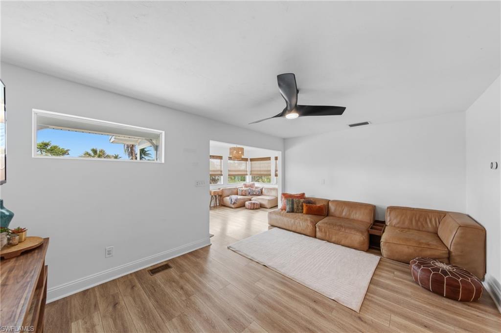 Living area with light wood finished floors and ceiling fan