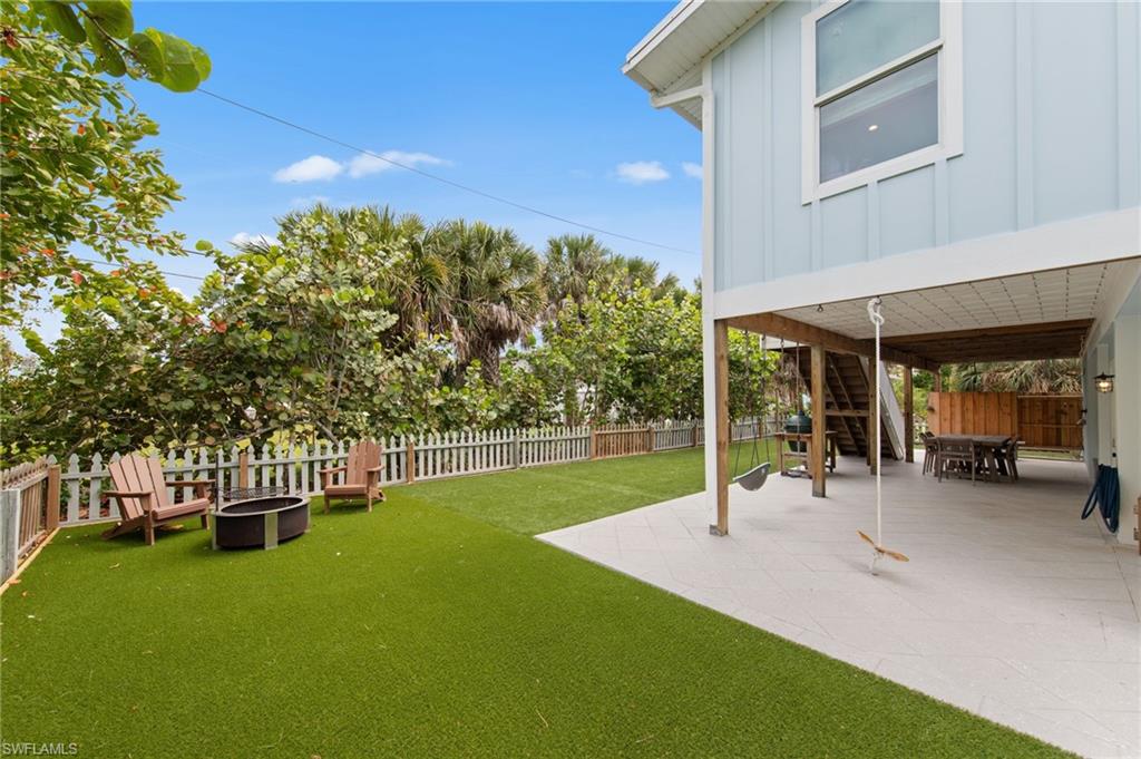 Fenced backyard with outdoor dining space and a patio.