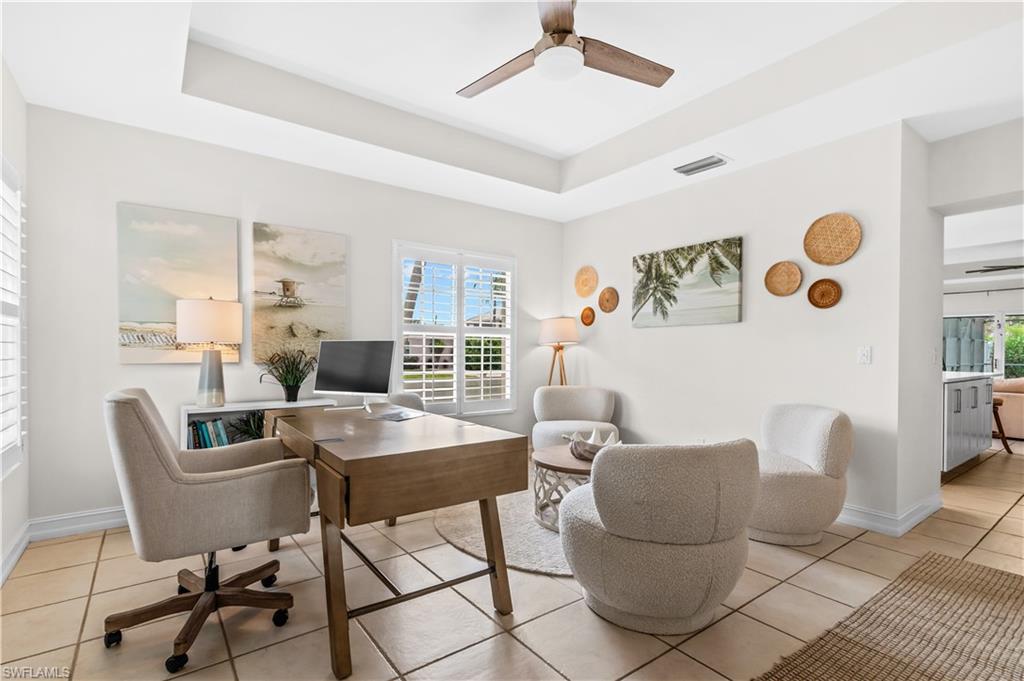 Open-concept kitchen featuring a large central island with seating, white shaker cabinetry, stainless steel appliances, and a subway tile backsplash