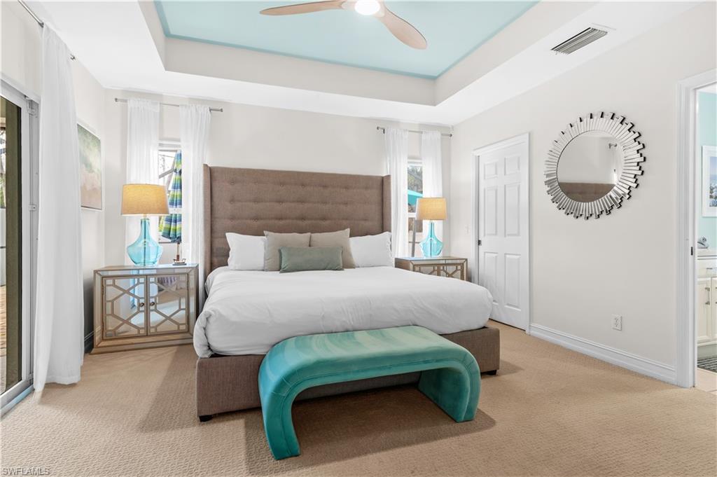 Recessed tray ceiling with light blue accent paint and a ceiling fan