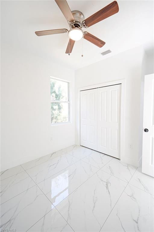Unfurnished bedroom featuring a closet, a ceiling fan, and light marble finish flooring. Photos are of a staged model or similar plan. Features and finishes may vary.