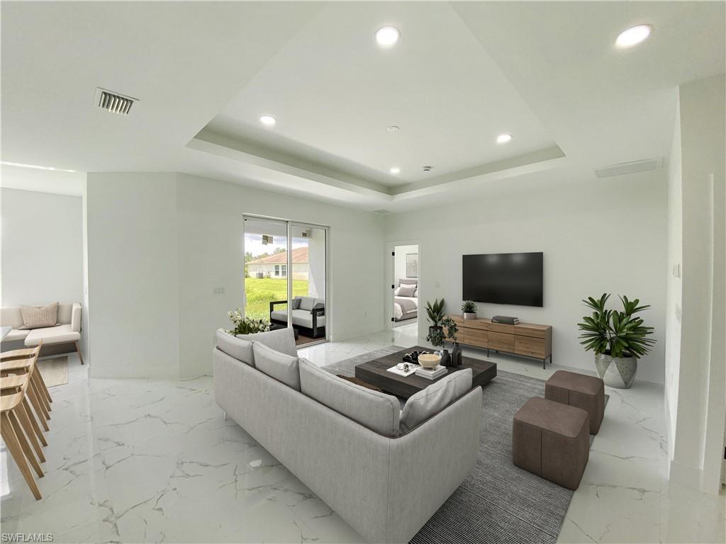 Living room with recessed lighting, light marble finish floors, and a tray ceiling. Photos are of a staged model or similar plan. Features and finishes may vary.