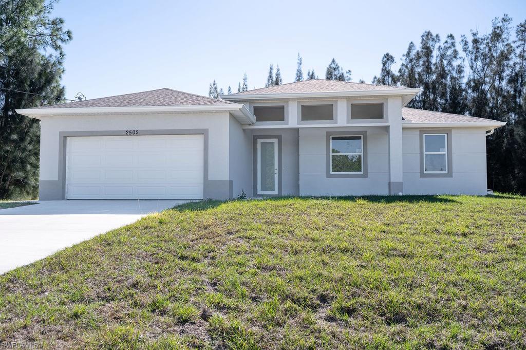 Prairie-style house with a front yard, stucco siding, driveway, a garage, and a shingled roof. Photos are of a staged model or similar plan. Features and finishes may vary.
