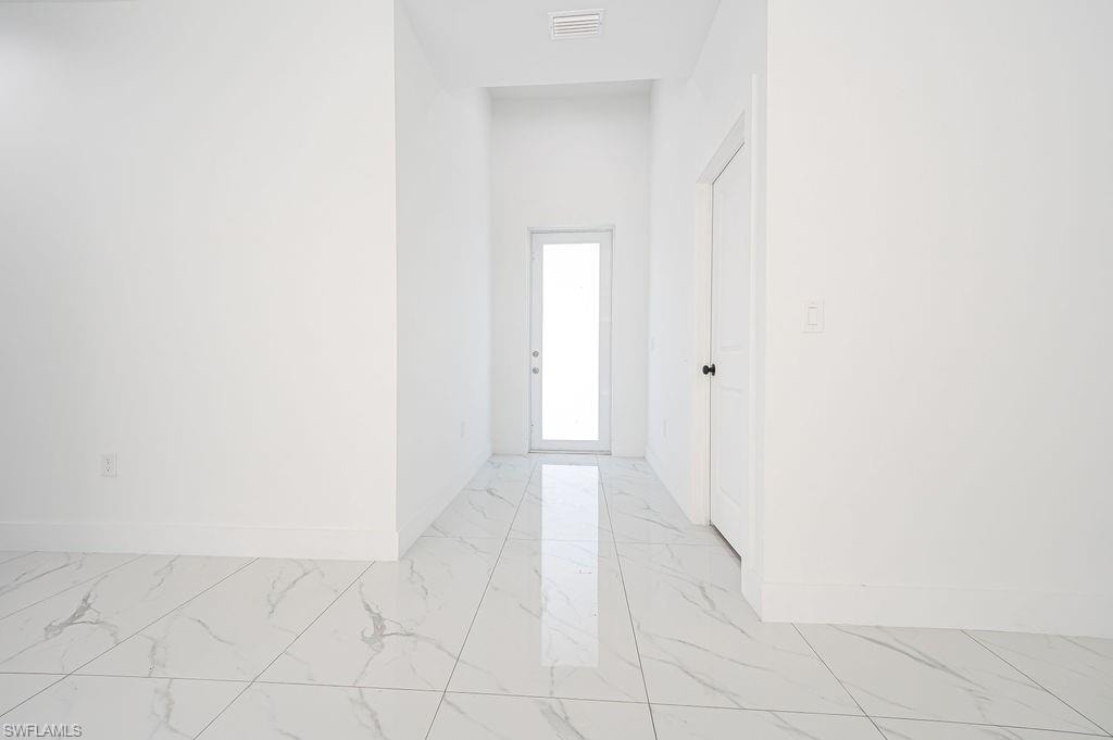 Corridor with light marble finish flooring and baseboards. Photos are of a staged model or similar plan. Features and finishes may vary.