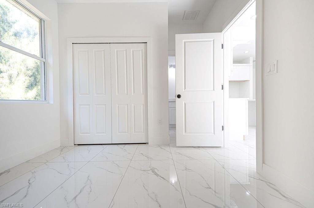 Unfurnished bedroom featuring a closet and light marble finish floors. Photos are of a staged model or similar plan. Features and finishes may vary.