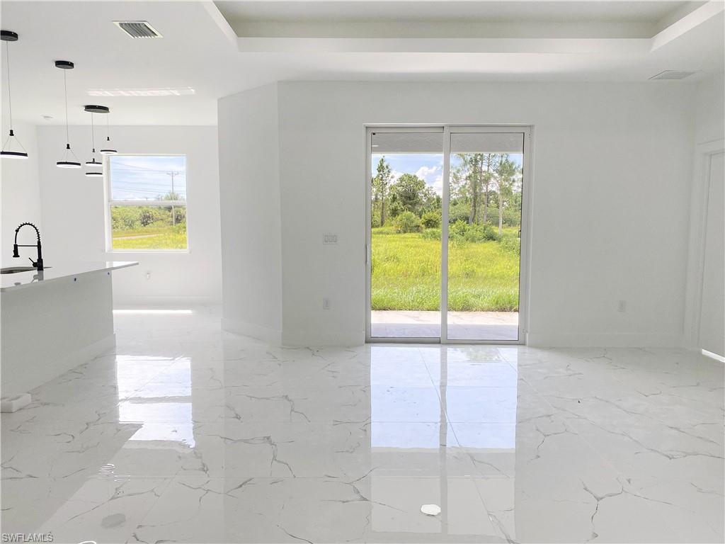Empty room featuring light marble finish flooring and a raised ceiling. Photos are of a staged model or similar plan. Features and finishes may vary.