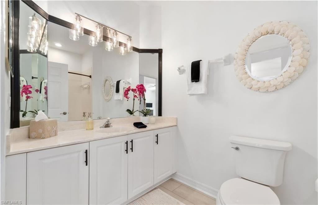 Full bathroom with vanity, toilet, baseboards, tile patterned floors, and walk in shower