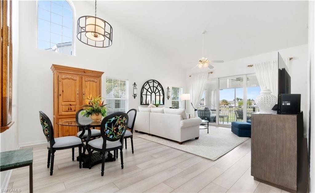 Dining room featuring ceiling fan, high vaulted ceiling, and light wood finished floors