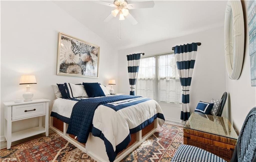Bedroom with baseboards, vaulted ceiling, and a ceiling fan