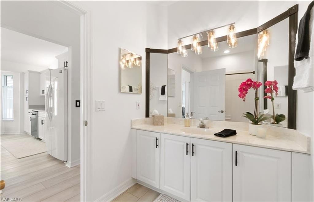 Bathroom with baseboards, wood finished floors, and vanity