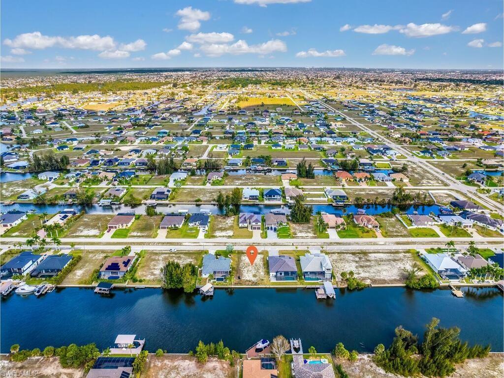 Aerial view of property and surrounding area featuring nearby suburban area and a nearby body of water
