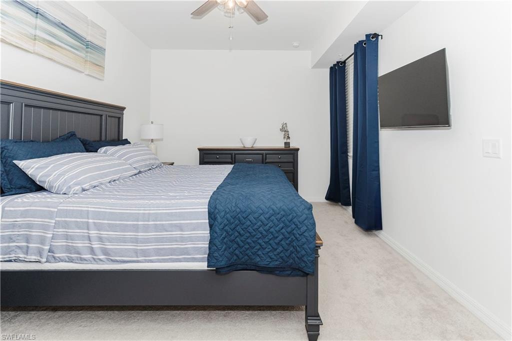 Carpeted bedroom featuring ceiling fan