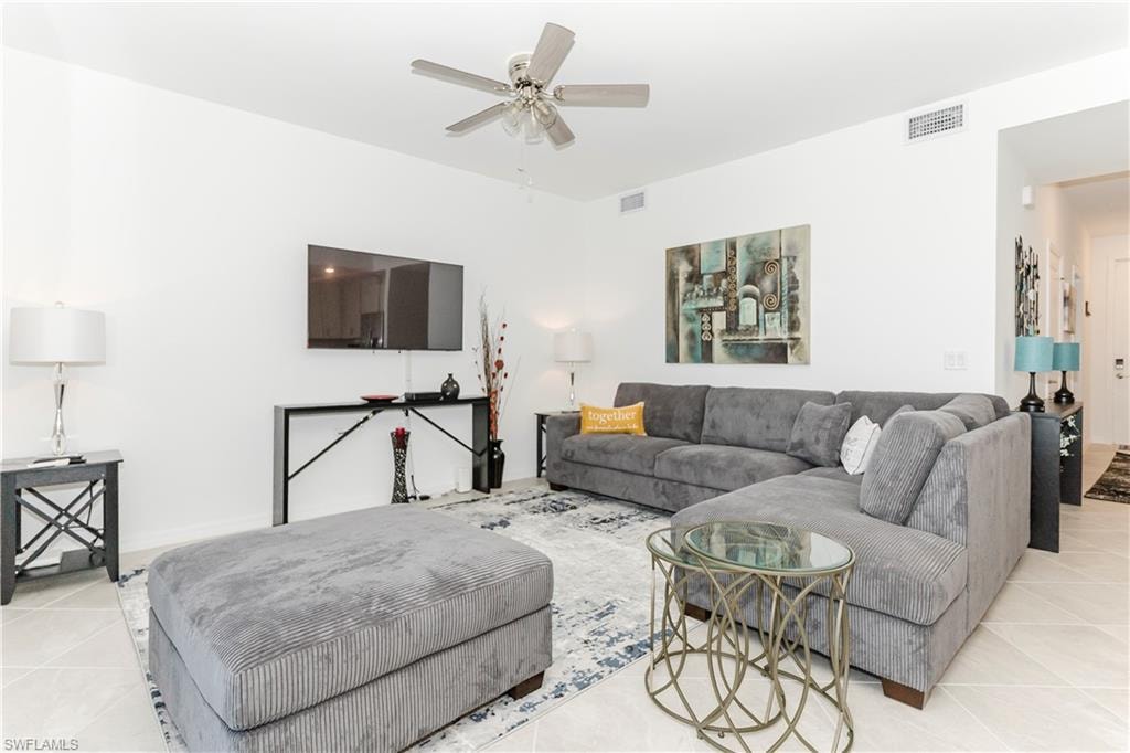 Living area featuring light tile patterned floors and a ceiling fan