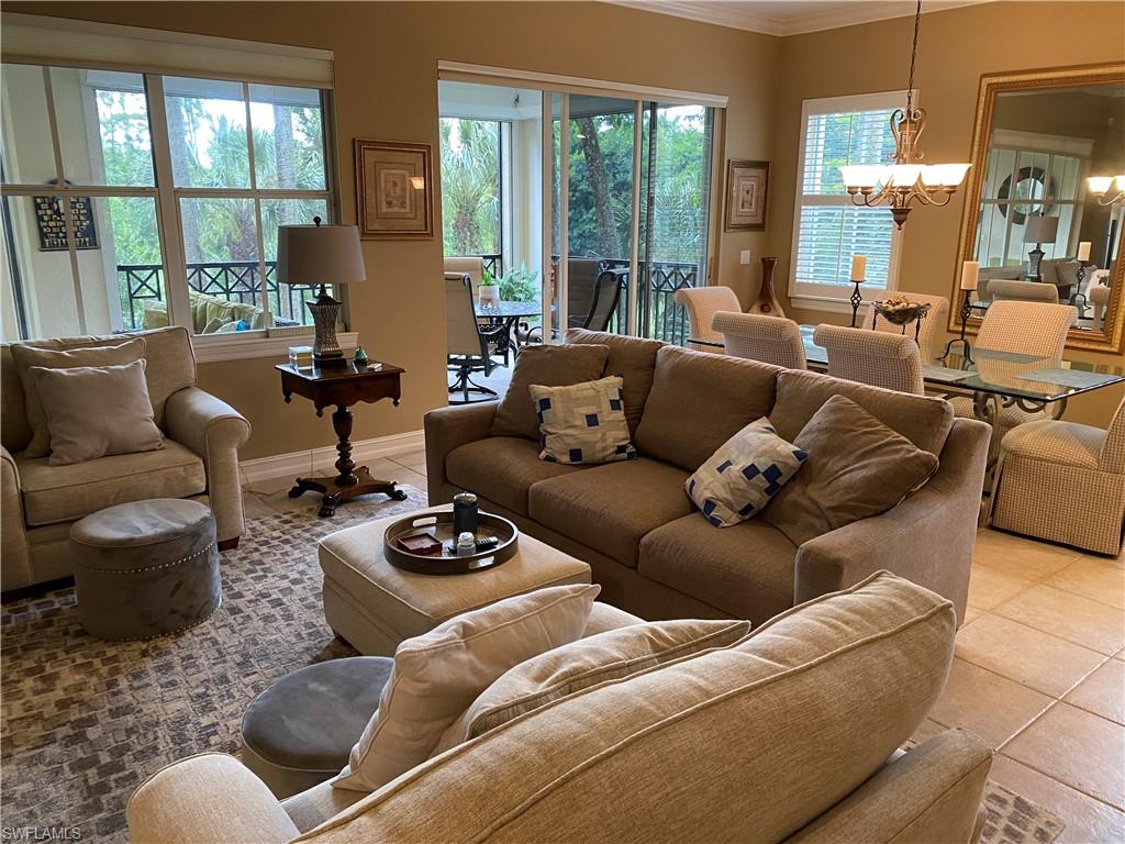 Living area featuring a chandelier, ornamental molding, and light tile patterned flooring