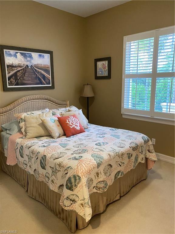 Bedroom with light colored carpet and baseboards