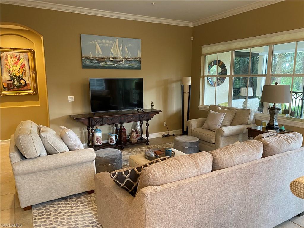 Tiled living room with ornamental molding and baseboards