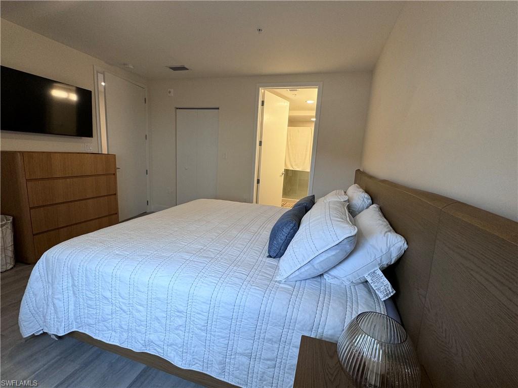 Bedroom with connected bathroom and hardwood / wood-style flooring