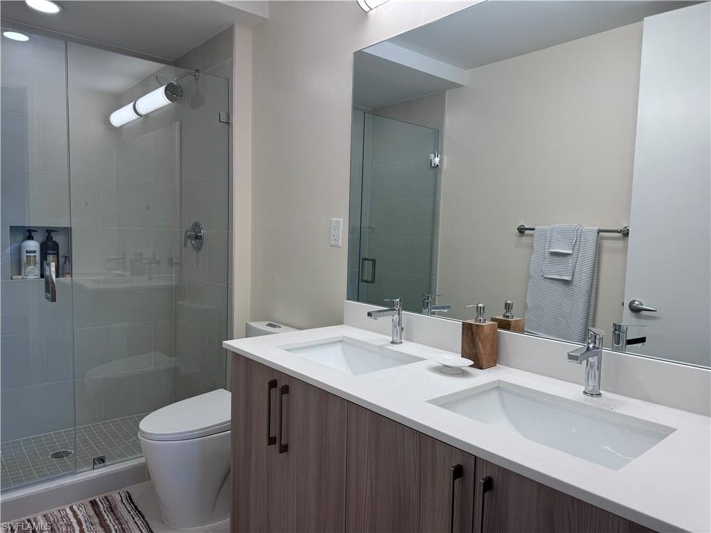 Bathroom with vanity, toilet, and a shower with door
