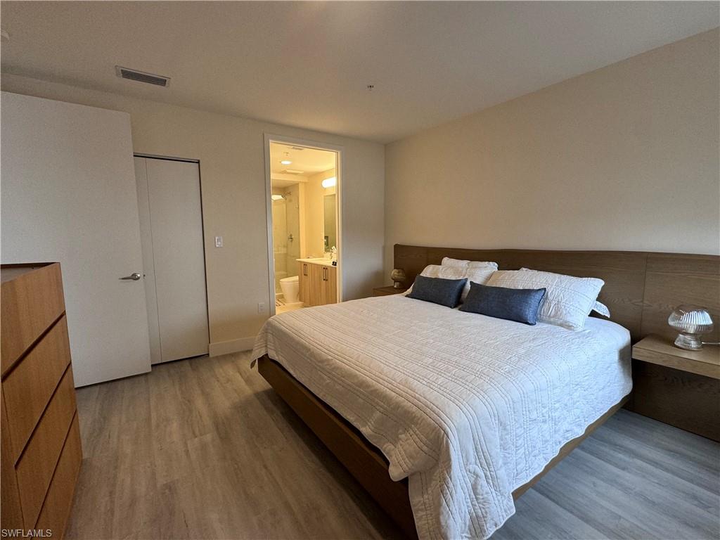 Bedroom featuring connected bathroom, a closet, and wood-type flooring