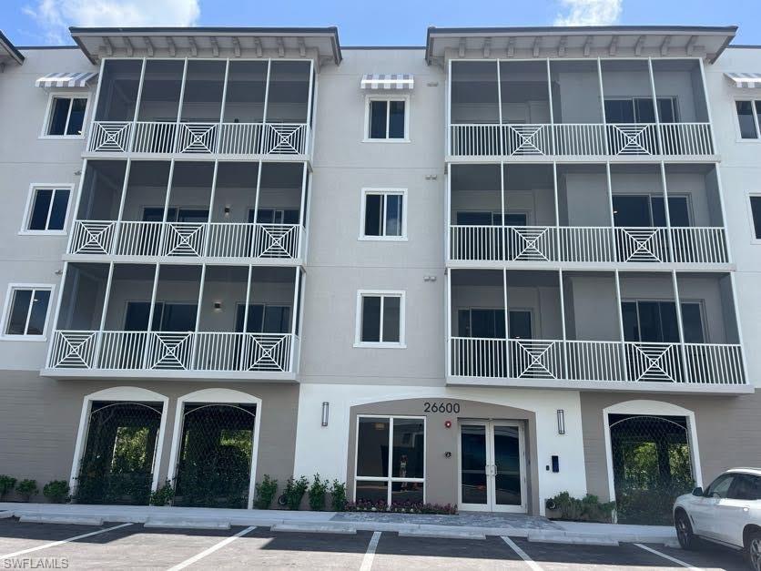 View of apartment building / complex with uncovered parking